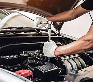 A person working on the engine of a car.
