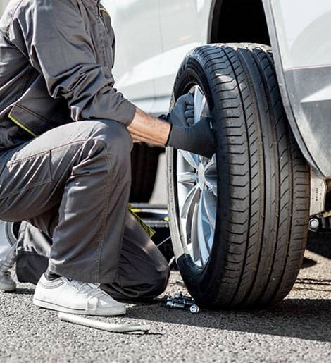 A man is changing the tire on his car.